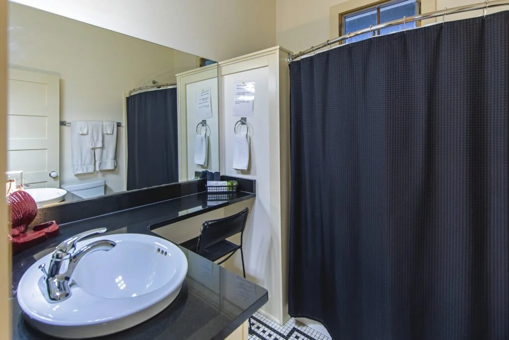Flat 4 bathroom features both a shower and tub, with steps to sit on and relax.